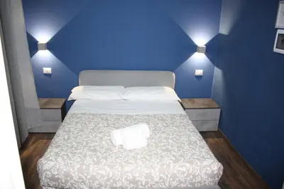 a blue room with a bed with a white bedspread at My Rhome Prati in Rome