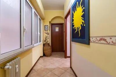 a hallway with yellow walls and a blue painting on the wall at Vatican Mami in Rome