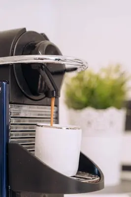 a cup of coffee is being poured into a coffeemachine at Duke's Apartment in Rome