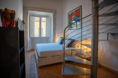 a bedroom with a bed and a spiral staircase at PgrHome Domus Pantheon in Rome