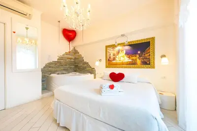 a bedroom with a white bed with a heart on it at Suites Roma Tiburtina in Rome
