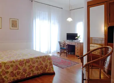 a bedroom with a bed and a desk with a television at Hotel Lancelot in Rome