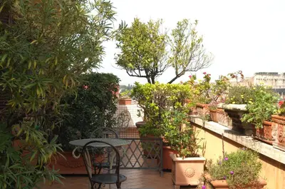 a patio with a table and chairs and plants at Hotel Lancelot in Rome