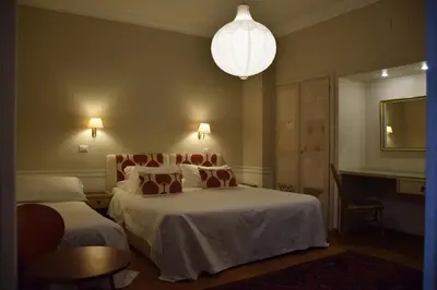 a hotel room with two beds and a chandelier at Hotel Lancelot in Rome
