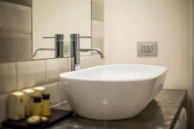 a bathroom with a white sink and a mirror at Trevi Contemporary Suite in Rome