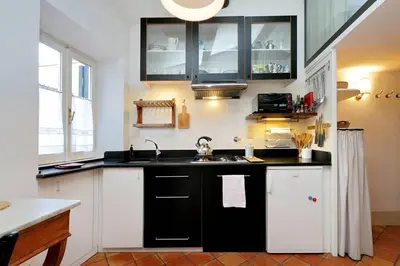a kitchen with black and white cabinets and a sink at Trastevere Charming Loft | Romeloft in Rome
