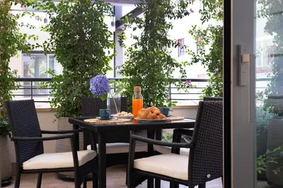 a table and chairs on a balcony with a table and drinks at Casa Scalzi in Rome