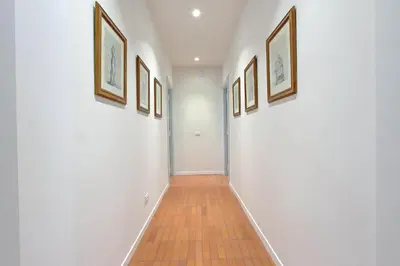 a hallway with white walls and framed pictures at Residenza Torre Vecchiarelli - apt 3 in Rome
