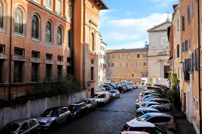 a row of cars parked on a street between buildings at Residenza Torre Vecchiarelli - apt 3 in Rome