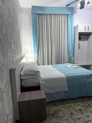a bedroom with a bed and a blue curtain at Guesthouse Alex II in Rome