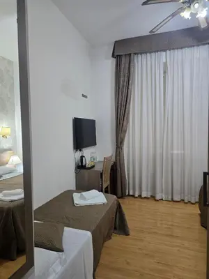 a hotel room with a bed and a television at Guesthouse Alex II in Rome