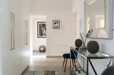 a white room with a glass table and a chair at Maison Letizia Roma in Rome