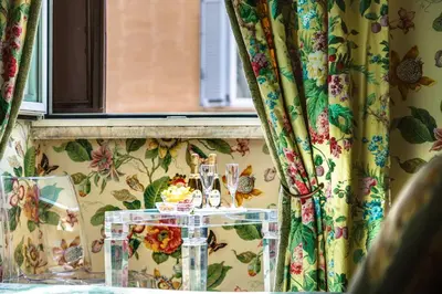 a table in a room with floral curtains and a window at Casa Heberart Guest House Sistina in Rome