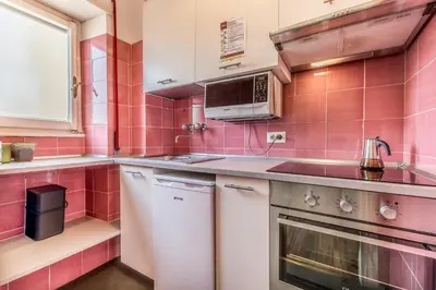 a pink tiled kitchen with a sink and a stove at Il Palazzetto di Via della Frezza in Rome