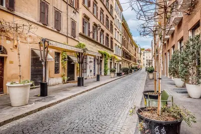 an empty street with potted plants and buildings at Il Palazzetto di Via della Frezza in Rome