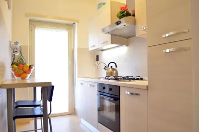 a kitchen with white cabinets and a stove top oven at Roma Caput Mundi in Rome