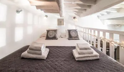 a bedroom with a large bed with two chairs on it at Sweet Campo de Fiori in Rome