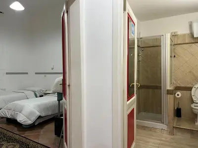 a bedroom with two beds and a bathroom at Zidan Guest House in Rome