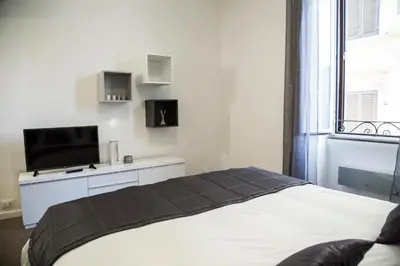 a bedroom with a bed and a tv and a window at Argentina Exclusive Apartment in Rome