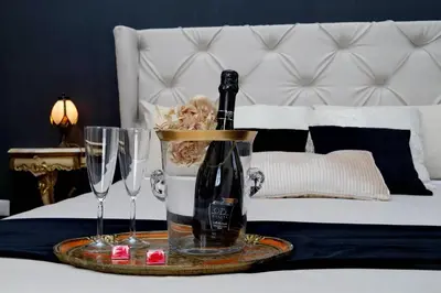 a bottle of champagne and two glasses on a bed at Dolce Casa Colosseo in Rome
