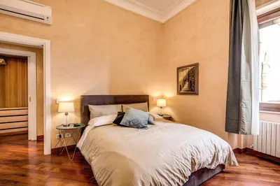 a bedroom with a large bed with two lamps at DOWNTOWN SRL - Imperial Panorama Penthouse in Rome