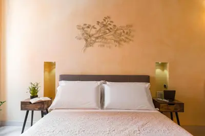 a bedroom with a bed with white sheets and two tables at TrinitaDeiMonti Guest House in Rome
