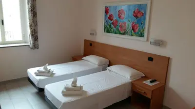 a room with two beds and a painting on the wall at Friendship Place in Rome