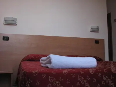 a bedroom with a bed with a white towel on it at Friendship Place in Rome