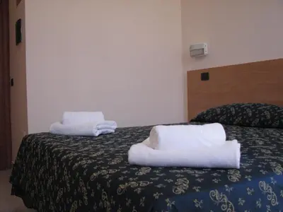 a hotel room with two towels on a bed at Friendship Place in Rome
