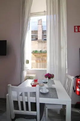 a white table and chairs in a room with a window at ROMA - Loft Campo de' Fiori - Appartamento Campo de' Fiori - LE CUGINE in Rome