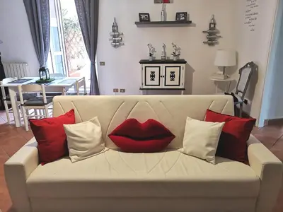 a couch with a red lips pillow on it at Chic 'N Charme Trastevere Terrace in Rome