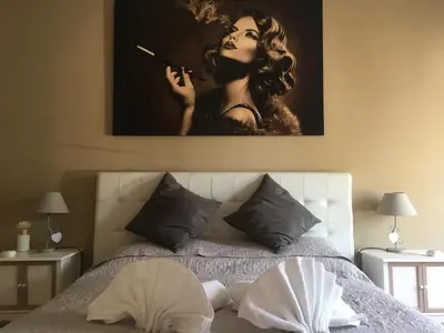 a bed with a picture of a woman smoking a cigarette at Chic 'N Charme Trastevere Terrace in Rome