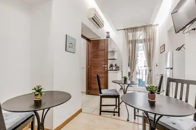 a living room with two tables and a kitchen at Vatican City Guest House in Rome
