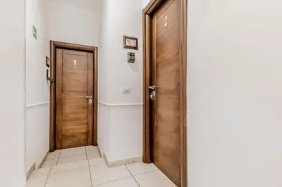 a hallway with a wooden door and a tile floor at Vatican City Guest House in Rome