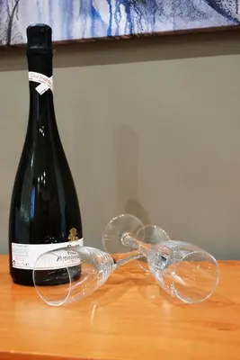 a bottle of wine and two wine glasses on a table at RHOMENJOY Suite Vatican in Rome