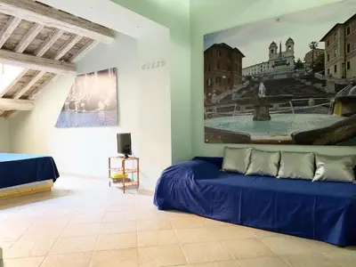 a vase with flowers on a table with a picture on the wall at Piazza di Spagna Prestige in Rome