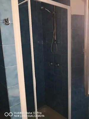 a bathroom with a shower with blue tiles at Trastevere four seasons Glorioso in Rome