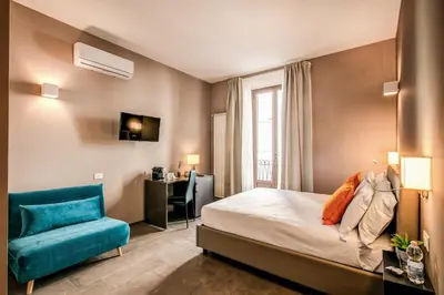 a hotel room with a bed and a blue couch at H501 Luxury Rooms in Rome