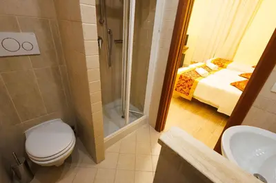 a bathroom with a toilet a sink and a shower at Hotel Terminal in Rome
