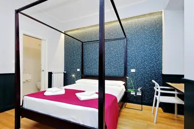 a bedroom with a canopy bed with a red blanket at Relais Vittoria Colonna in Rome