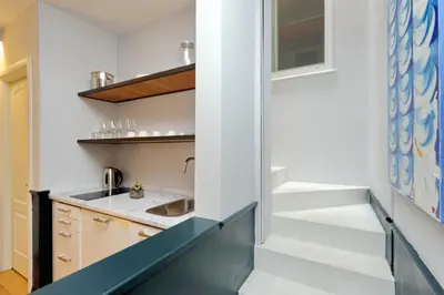 a stairway leading up to a kitchen with white walls at Relais Vittoria Colonna in Rome