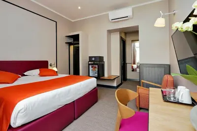 a hotel room with a large bed and a table at Relais Vittoria Colonna in Rome