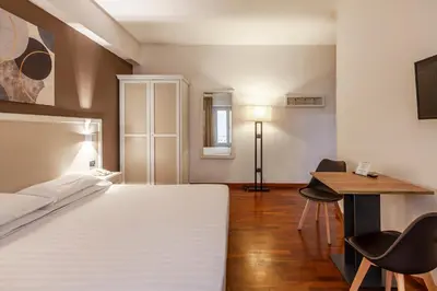 a bedroom with a bed and a desk and a table at Inn Rome Rooms & Suites in Rome