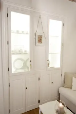 a living room with white cabinets and two windows at Paradise Suite Piazza Navona Campo de Fiori in Rome