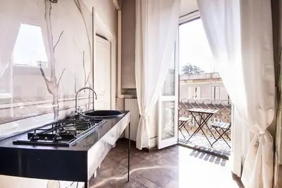 a kitchen with a stove top oven next to a window at Palazzo Giorgioli Apartment in Rome