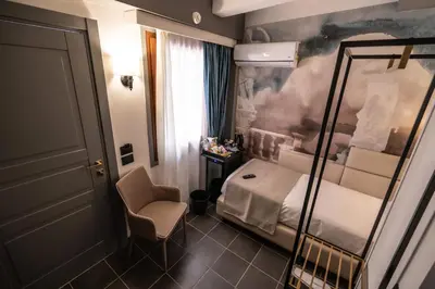 a small room with a bed and a chair at Relais Manzoni in Rome