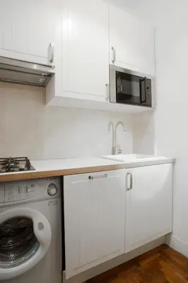 a kitchen with a washing machine and a microwave at Santa Cecilia Apartment in Via del Corso in Rome