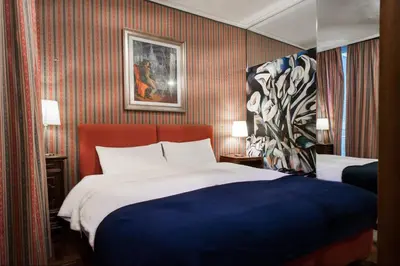 a hotel room with a bed and a painting on the wall at Santa Cecilia Apartment in Via del Corso in Rome