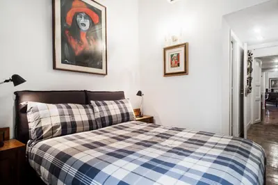 a bedroom with a bed with a checkered blanket at Santa Cecilia Apartment in Via del Corso in Rome