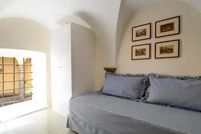 a bedroom with a bed with blue pillows and a window at Navona Charming Flat in Rome